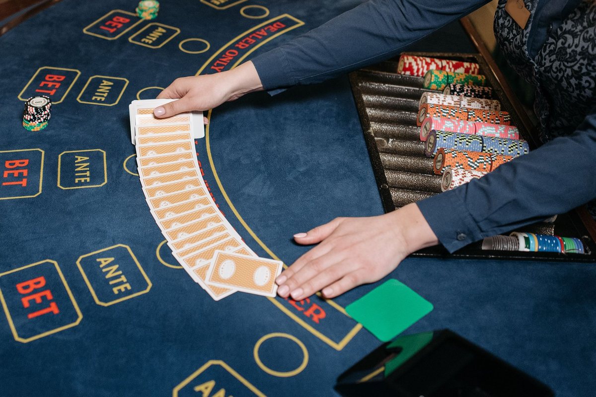 Professional dealer handling cards at a casino table